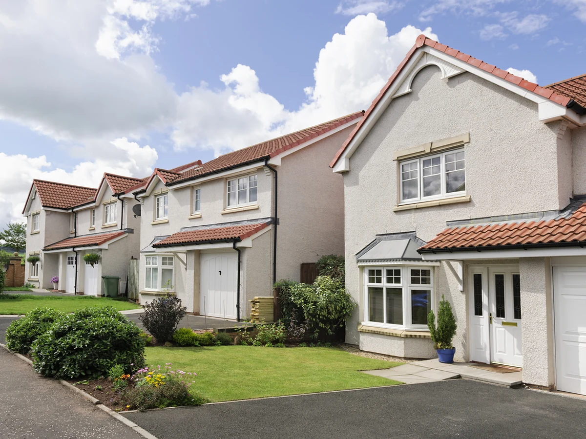 Exterior painting on a row of modern British homes in Swindon Village by Cheltenham Decorators
