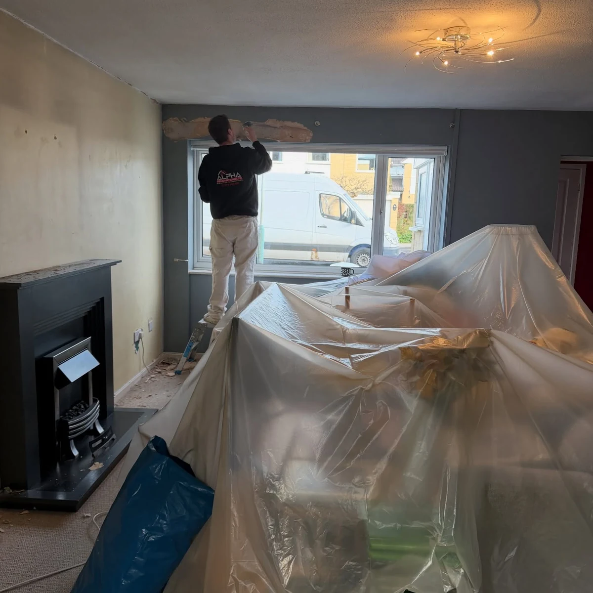 Decorator mid-project with dust sheets down during an interior repaint in Cheltenham