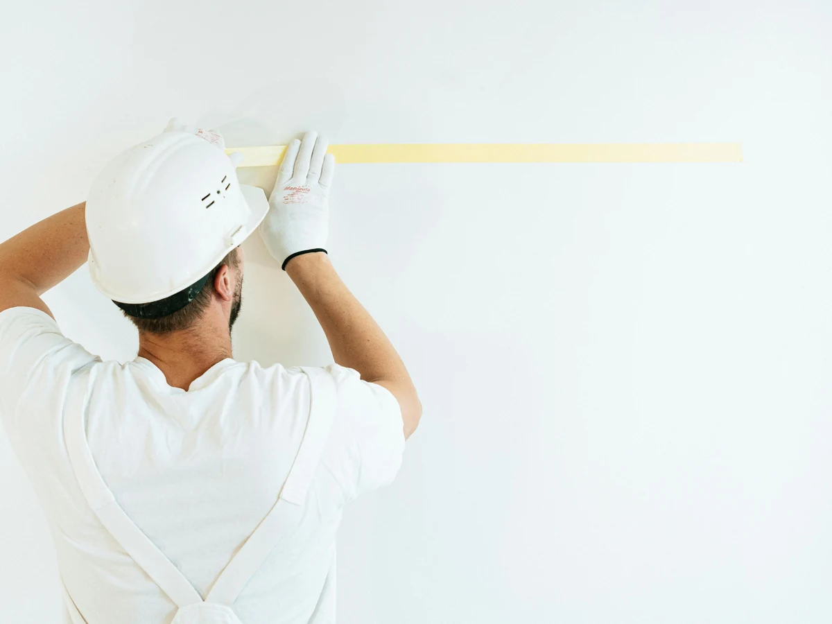 Painter applying masking tape for decorating work in Stroud by Cheltenham Decorators
